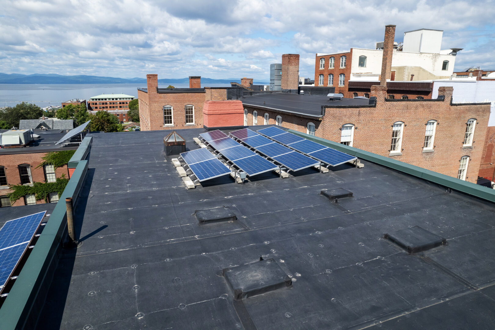 A new flat EPDM rubber roof on a commercial building with solar panels in Burlington, Vermont.