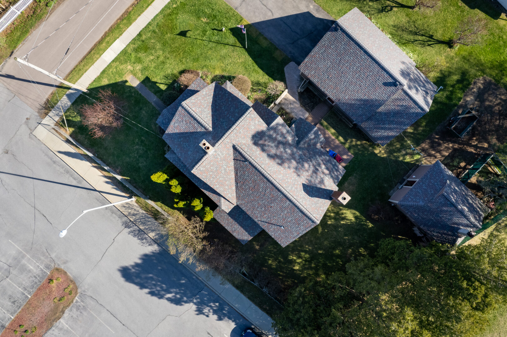 Overhead view of a two-story home, garage and storage shed that all underwent full roof replacements in Essex Junction, VT. 