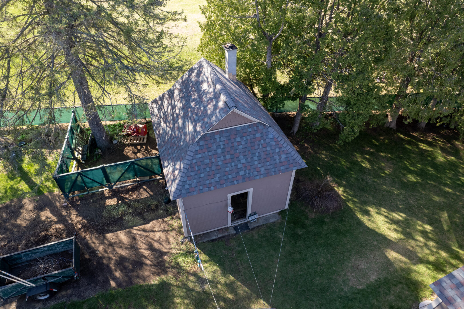 A small storage shed in the backyard of a home in Vermont that touts a new asphalt shingle roof.