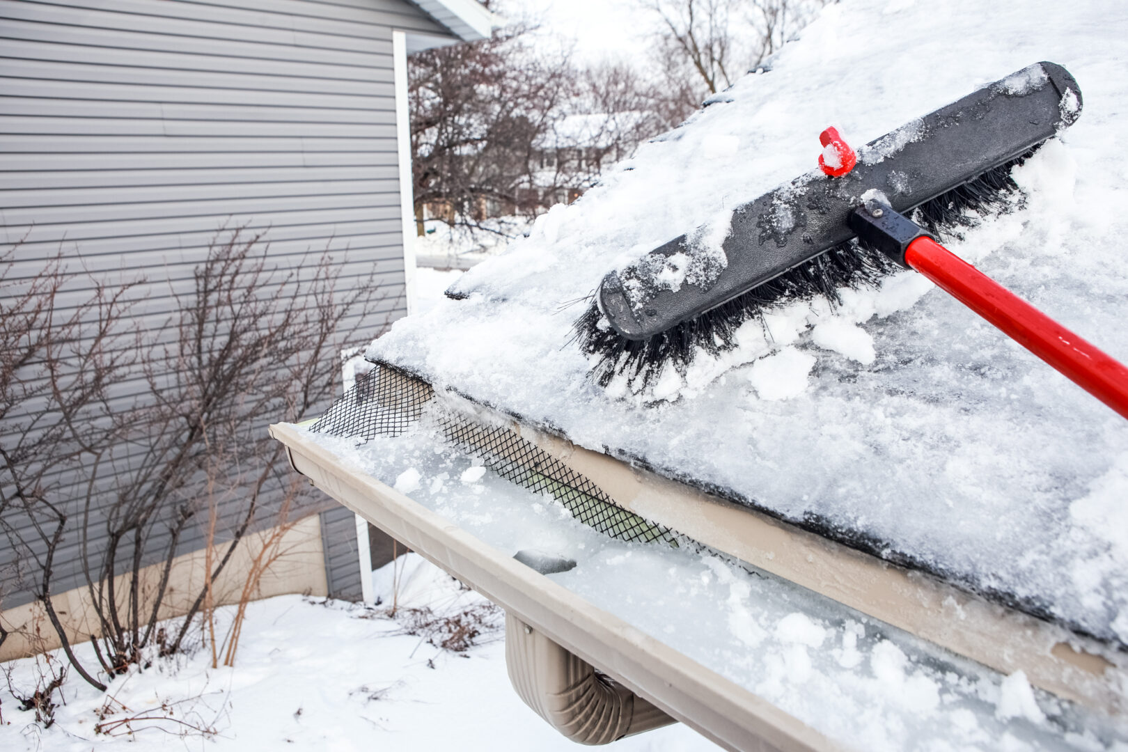 Gutters with ice dam and broom for raking snow off a roof