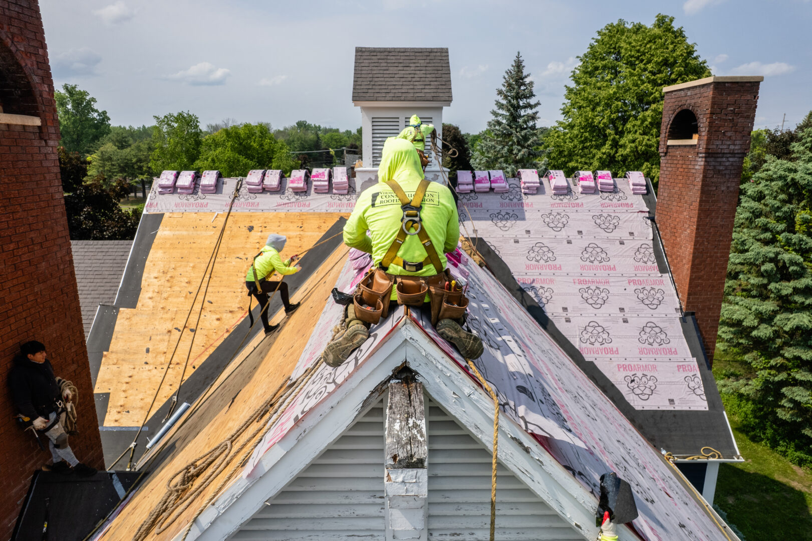 Construction worker in high visibility shirt on top of unfinished roof